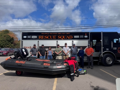 WVAC members beside an inflatable rescue boat and the black and orange Rescue Squad truck